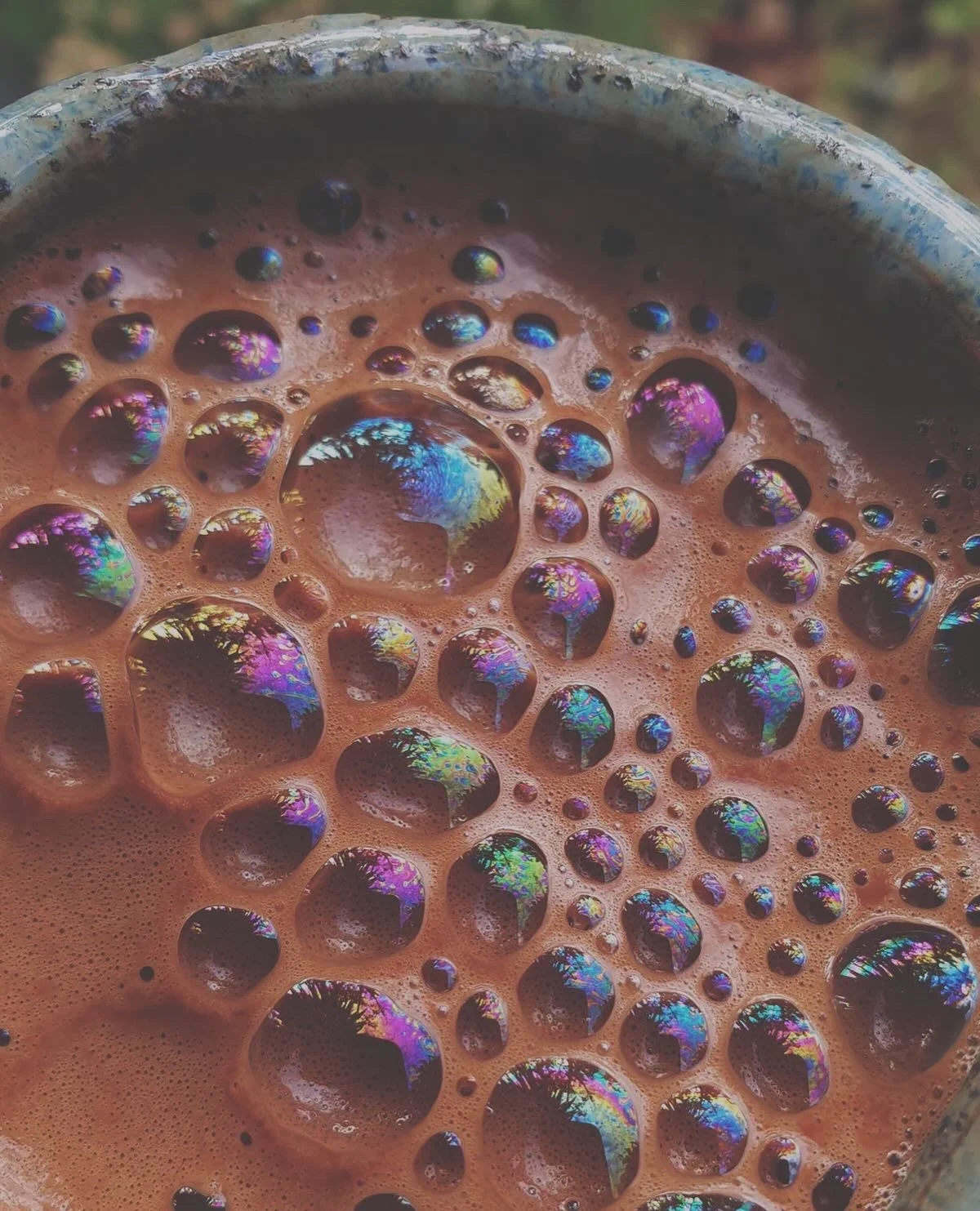 Close-up of frothy ceremonial cacao in a blue-glazed mug
