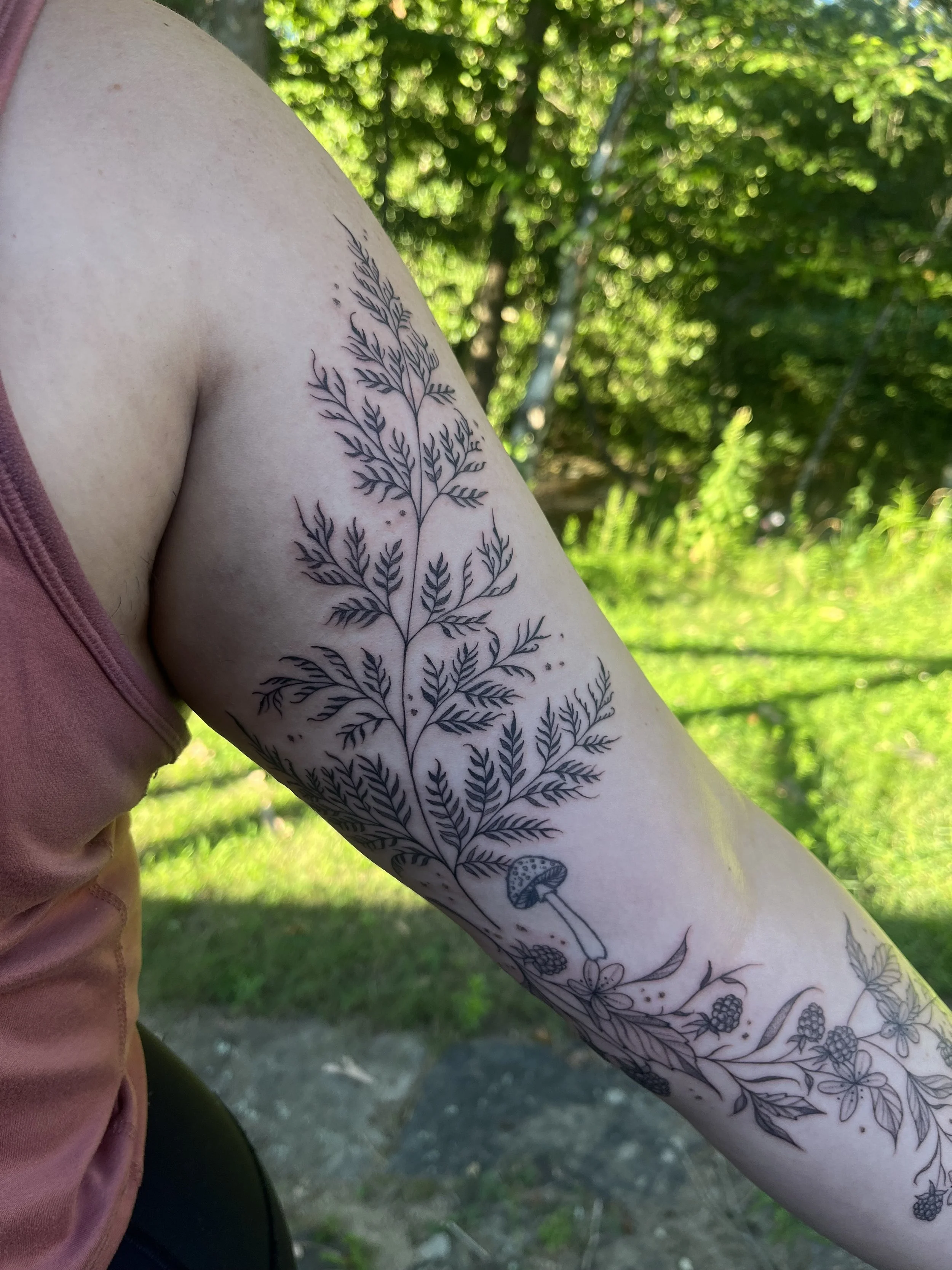 Fern, mushrooms, and berries on an arm