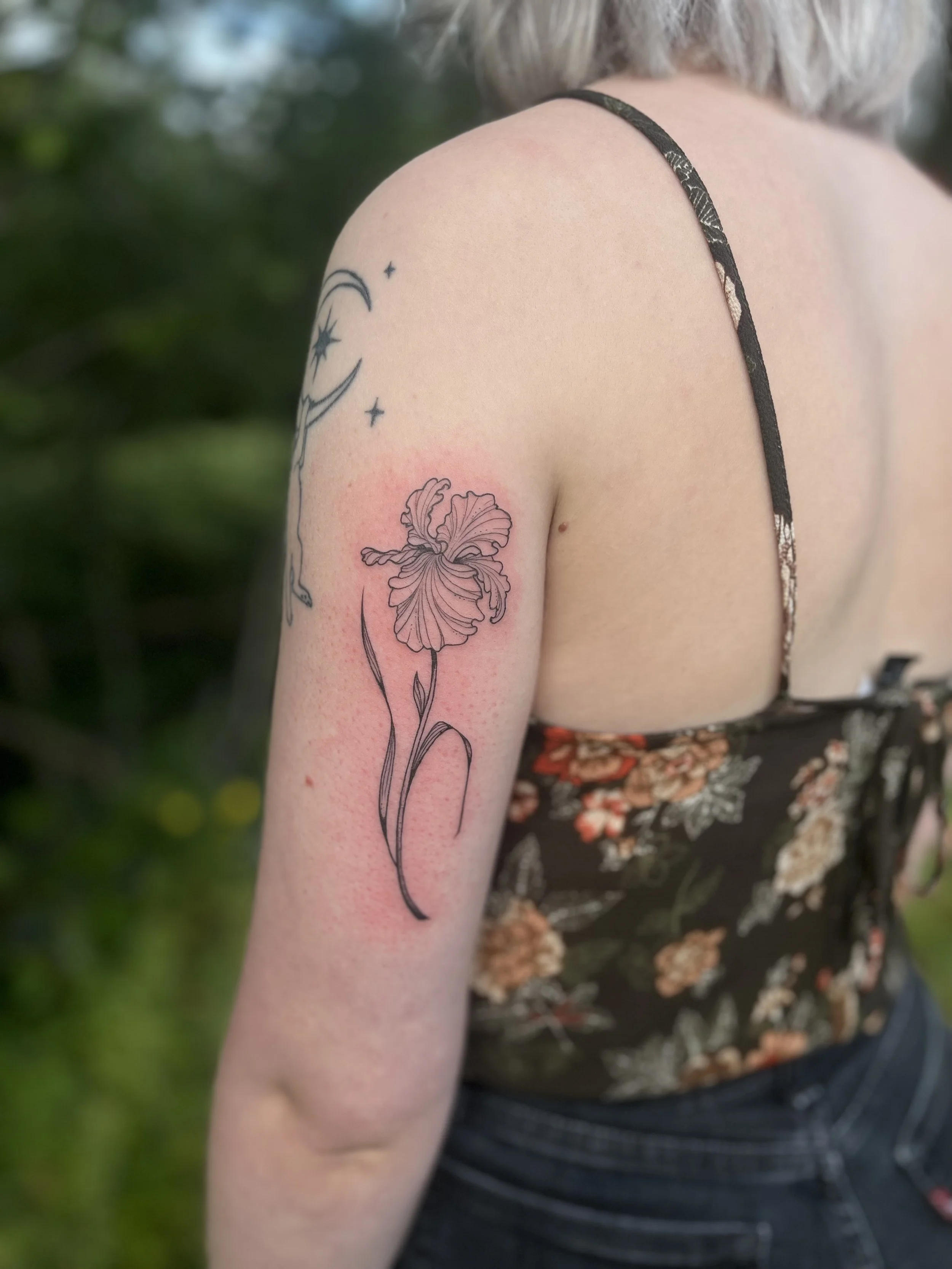 Flower and moon-star tattoos outdoors